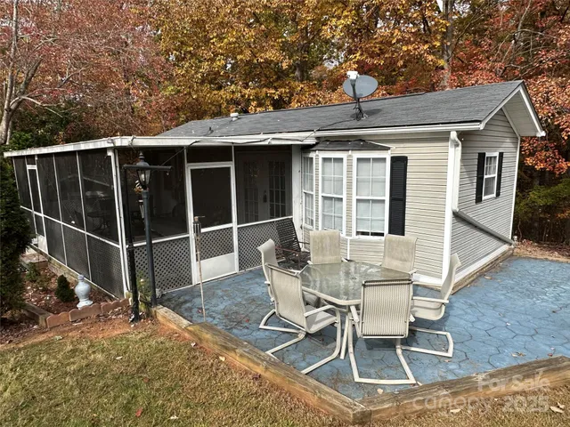 a view of a patio with table and chairs and wooden fence