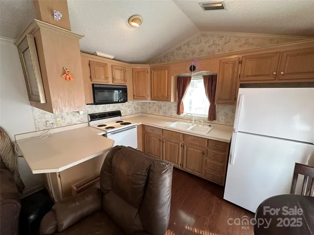a kitchen with a refrigerator and a stove top oven