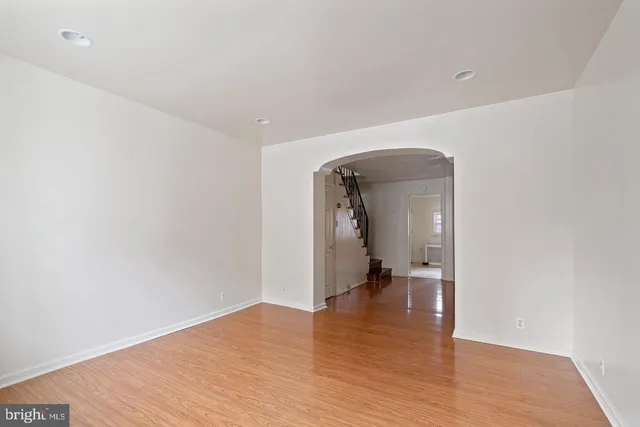 a view of a hallway with wooden floor and a refrigerator