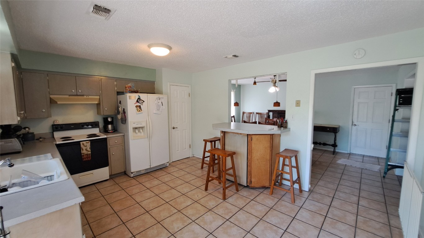 9005 Dorella Lane Austin, TX 78736 - Photo 12 of 38 a kitchen with stainless steel appliances a refrigerator sink and cabinets