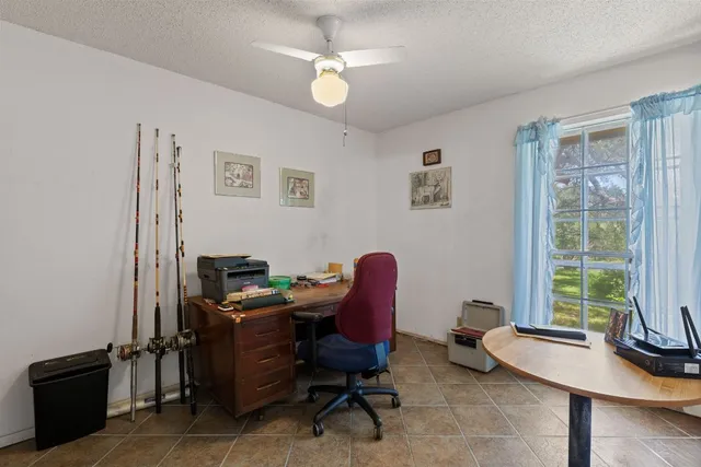 a view of a workspace with furniture and a window