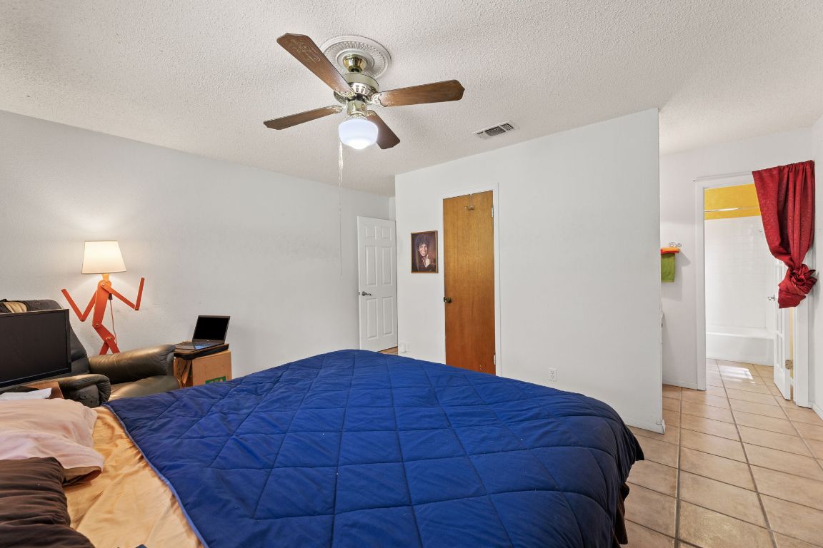 9005 Dorella Lane Austin, TX 78736 - Photo 22 of 38 a bedroom with a bed and a chandelier