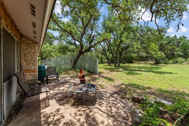 a view of a backyard with table and chairs and potted plants