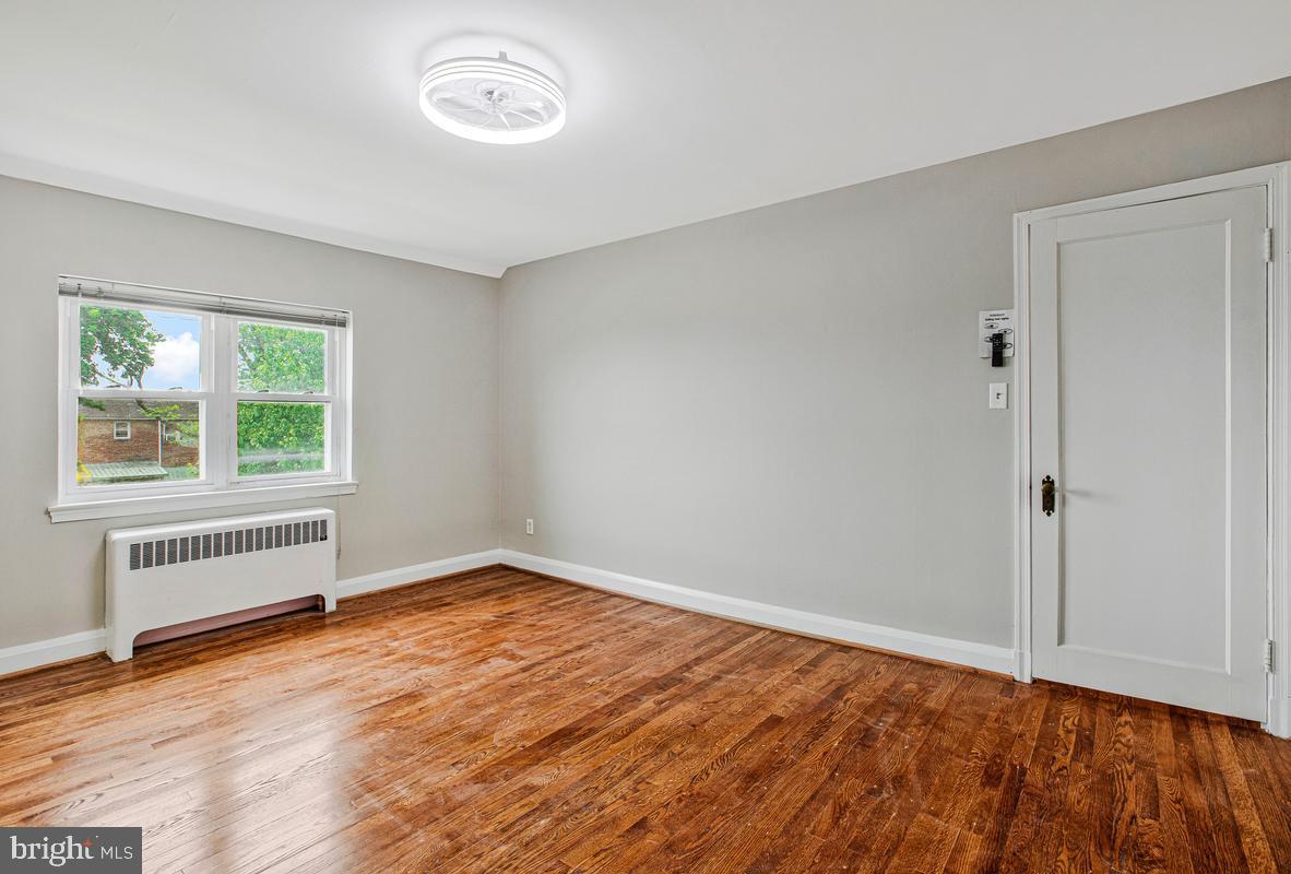3040 Federal Street Baltimore, MD 21213 - Photo 18 of 41 an empty room with wooden floor and windows