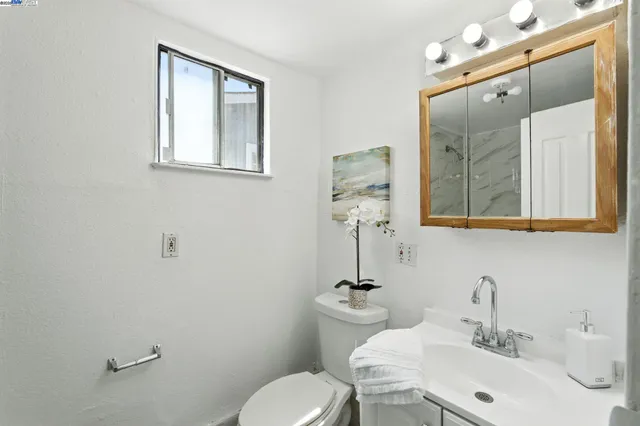 a bathroom with a toilet sink and mirror
