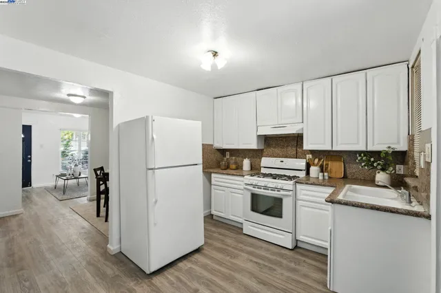 a kitchen with a refrigerator stove and white cabinets