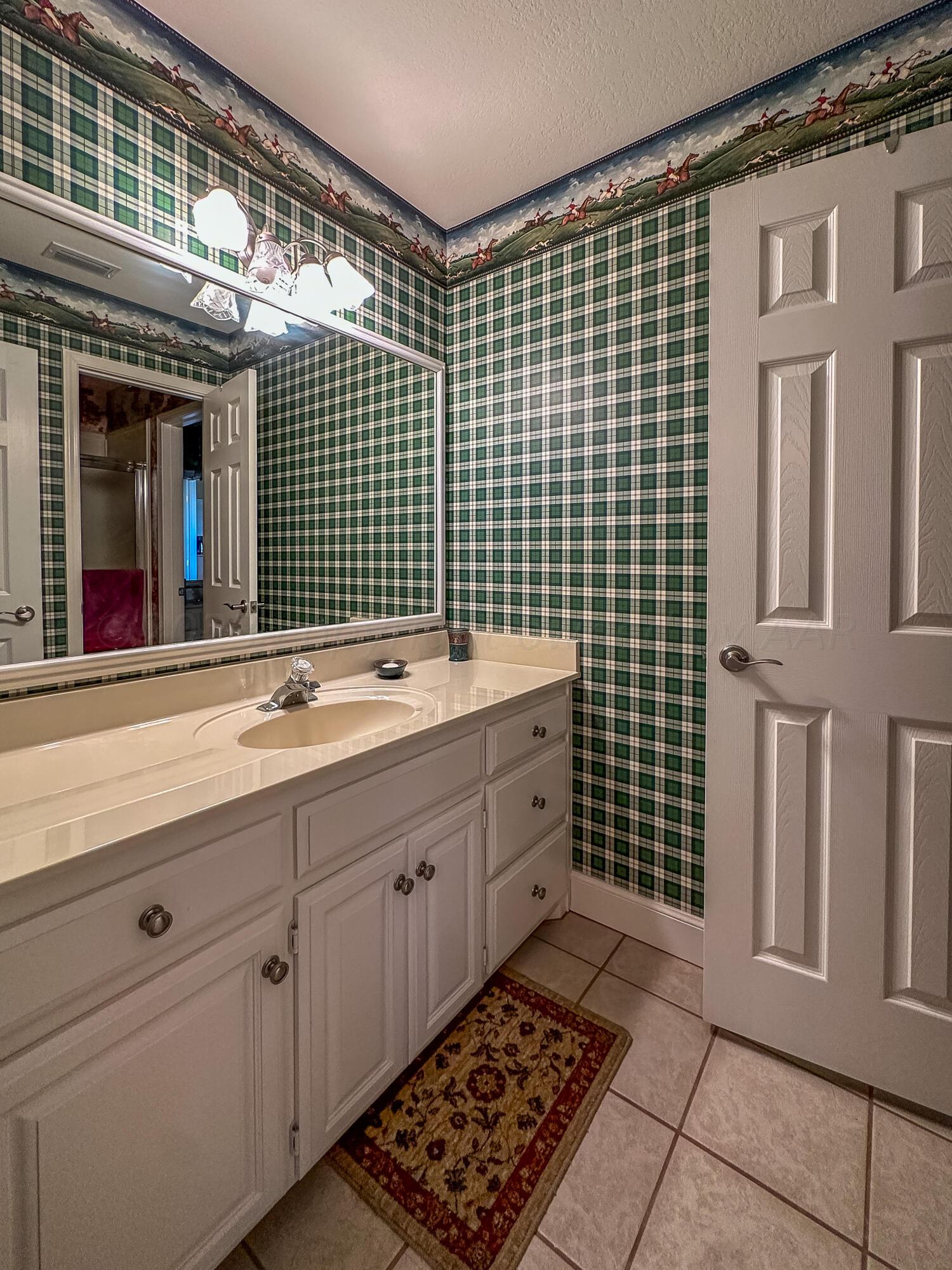 105 St James Street Borger, TX 79007 - Photo 29 of 36 a bathroom with a sink double vanity and a blue walk in closet