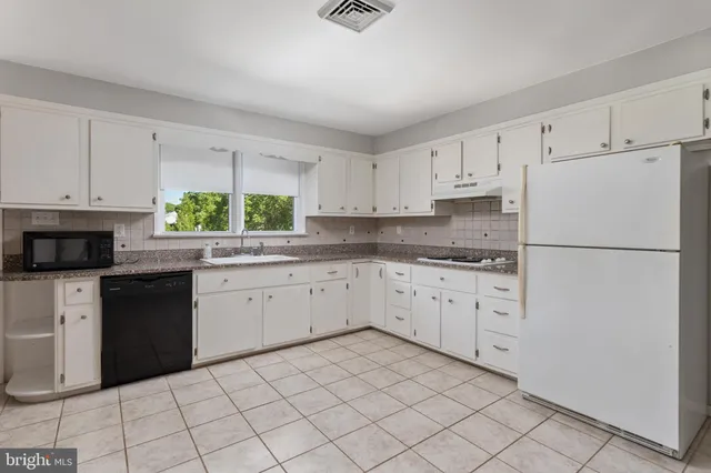 a kitchen with a stove top oven and sink