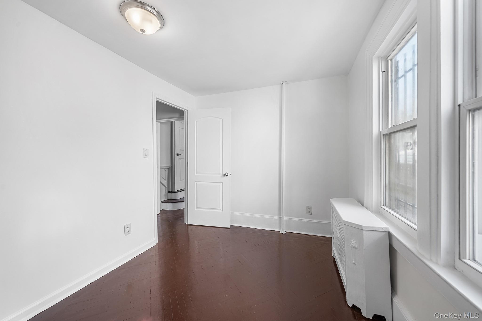150-44 87th Road Queens, NY 11432 - Photo 13 of 35 wooden floor in an empty room with a window