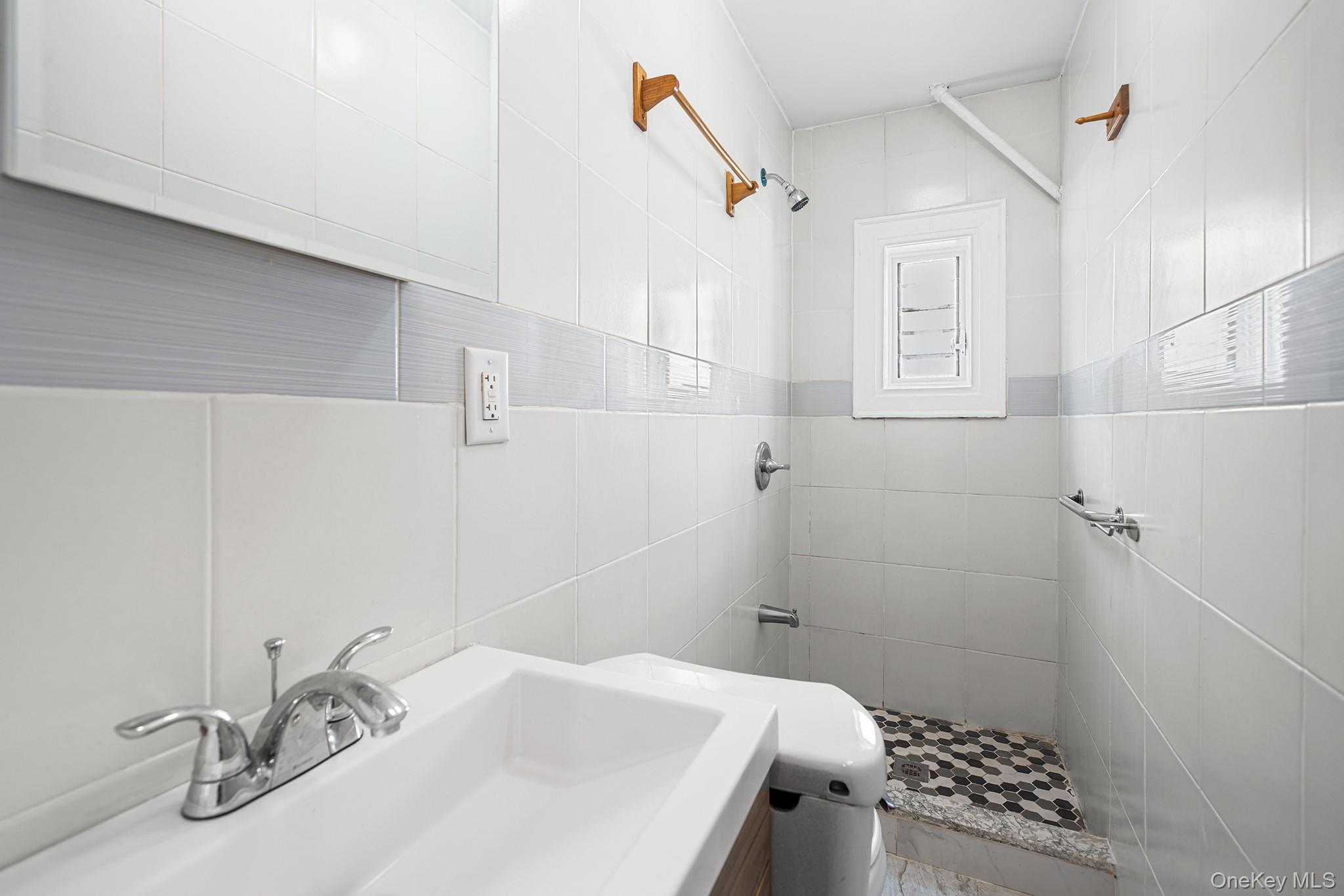 150-44 87th Road Queens, NY 11432 - Photo 15 of 35 a bathroom with a sink and shower