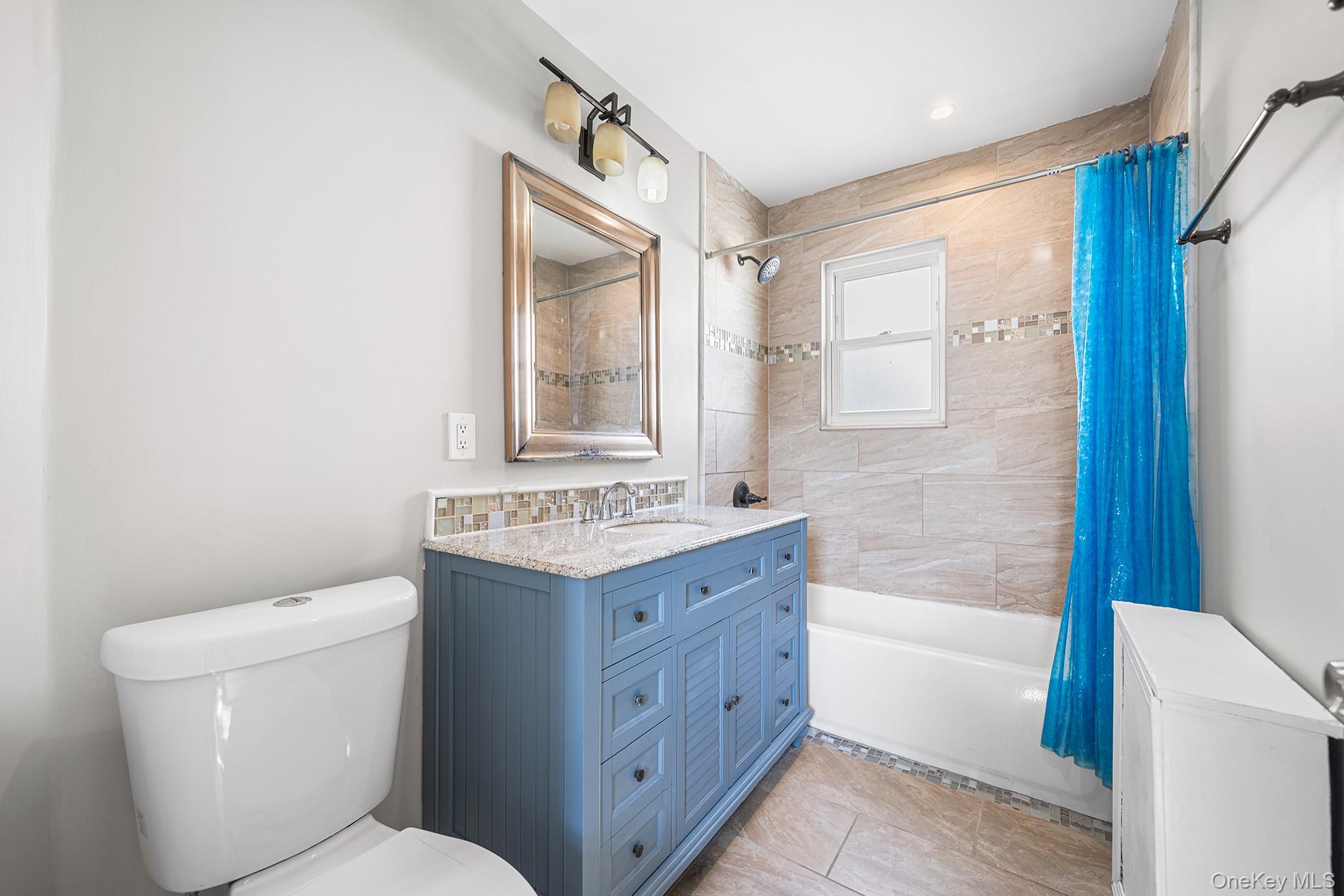 150-44 87th Road Queens, NY 11432 - Photo 17 of 35 a bathroom with a granite countertop toilet a sink and bathtub