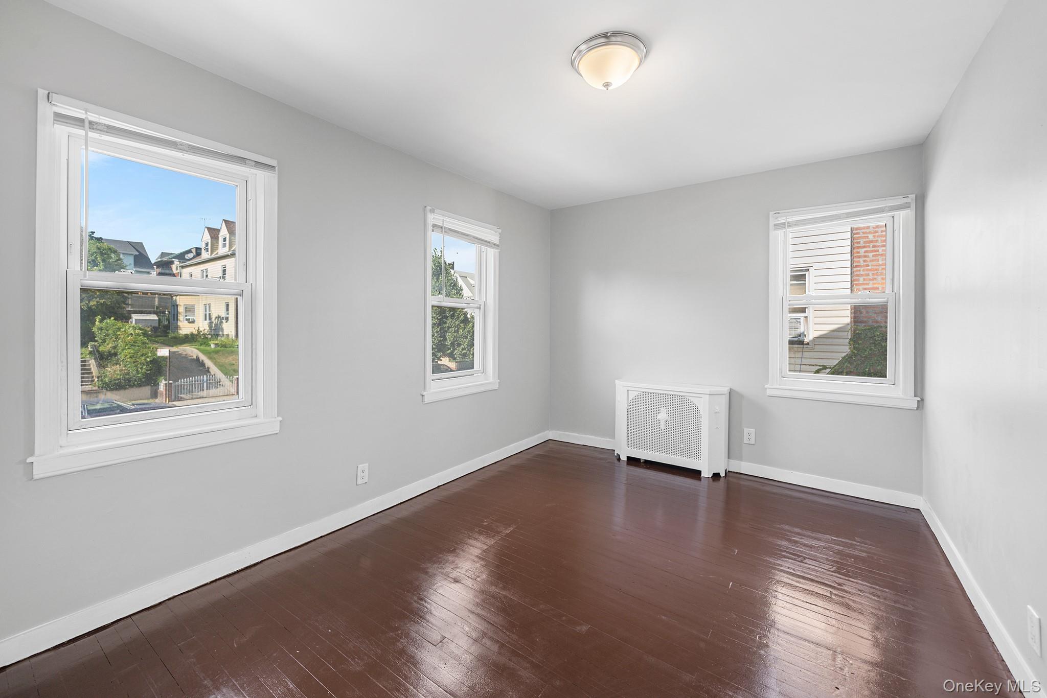 150-44 87th Road Queens, NY 11432 - Photo 19 of 35 a view of empty room with wooden floor and fan