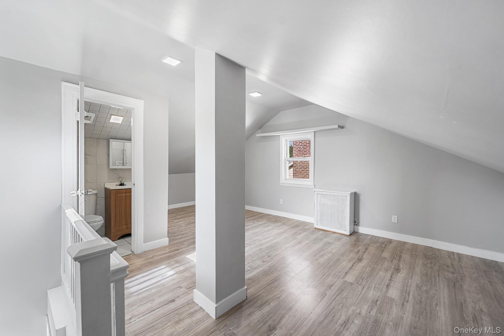 150-44 87th Road Queens, NY 11432 - Photo 21 of 35 an empty room with wooden floor and windows