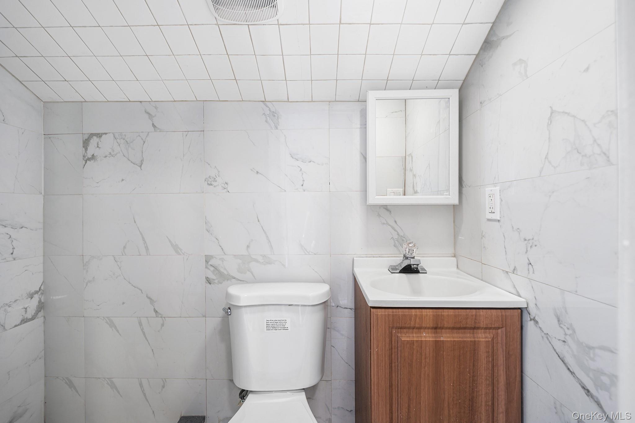 150-44 87th Road Queens, NY 11432 - Photo 24 of 35 a bathroom with a sink a toilet and a mirror