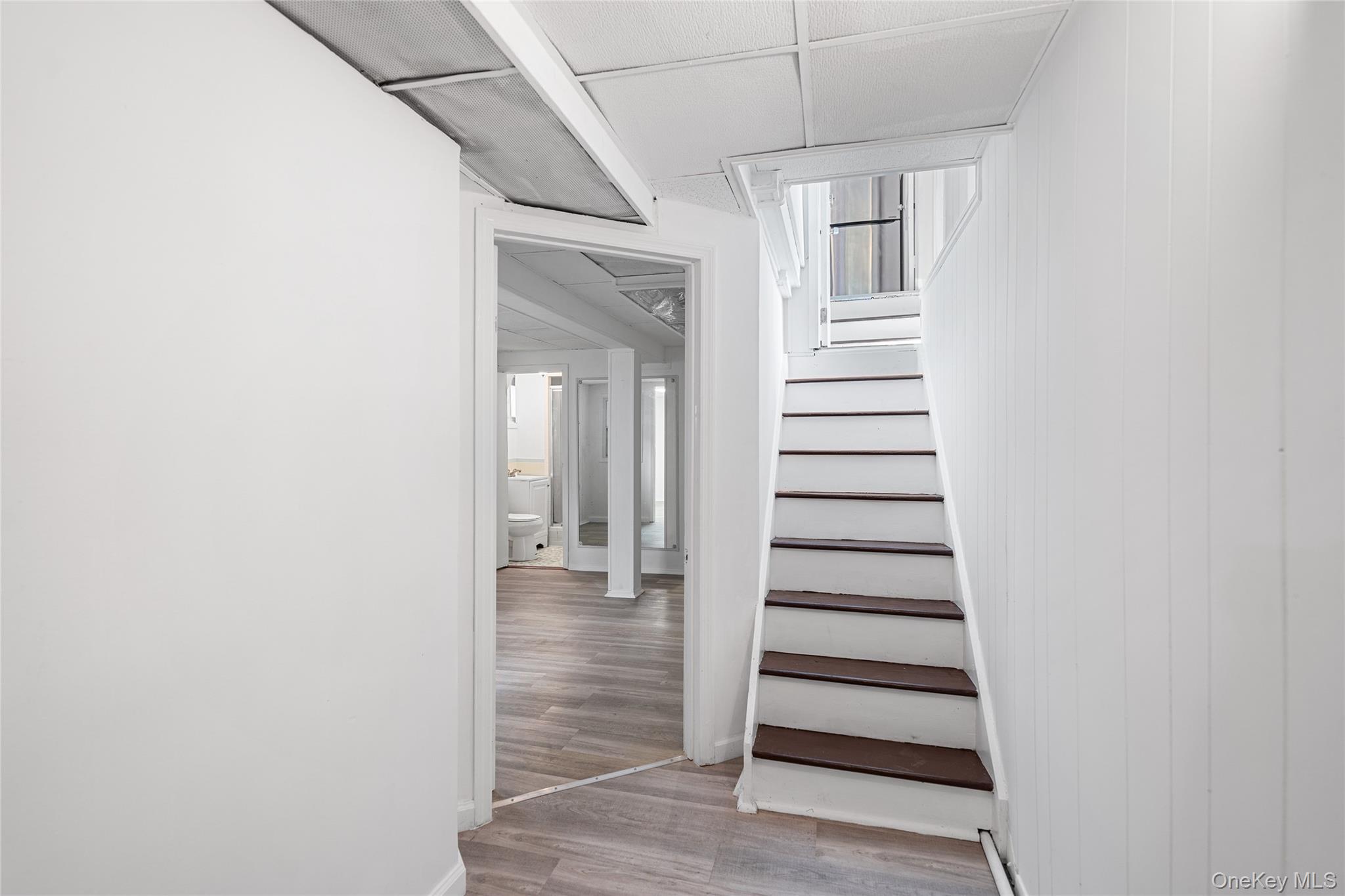 150-44 87th Road Queens, NY 11432 - Photo 26 of 35 an empty room with stairs and wooden floor