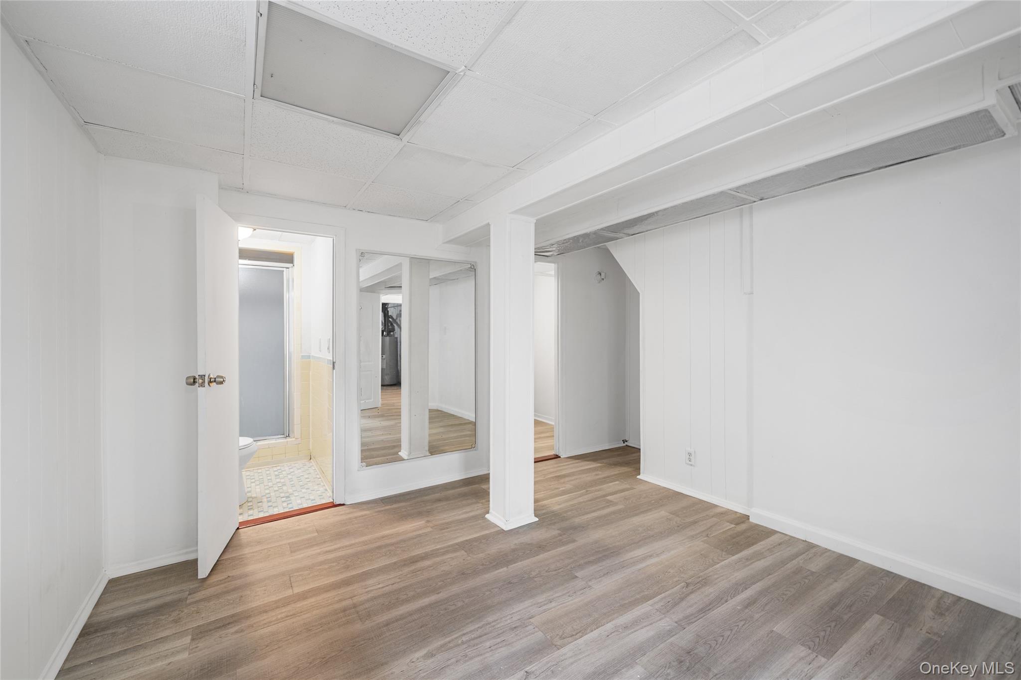 150-44 87th Road Queens, NY 11432 - Photo 28 of 35 a view of an empty room with wooden floor and a window