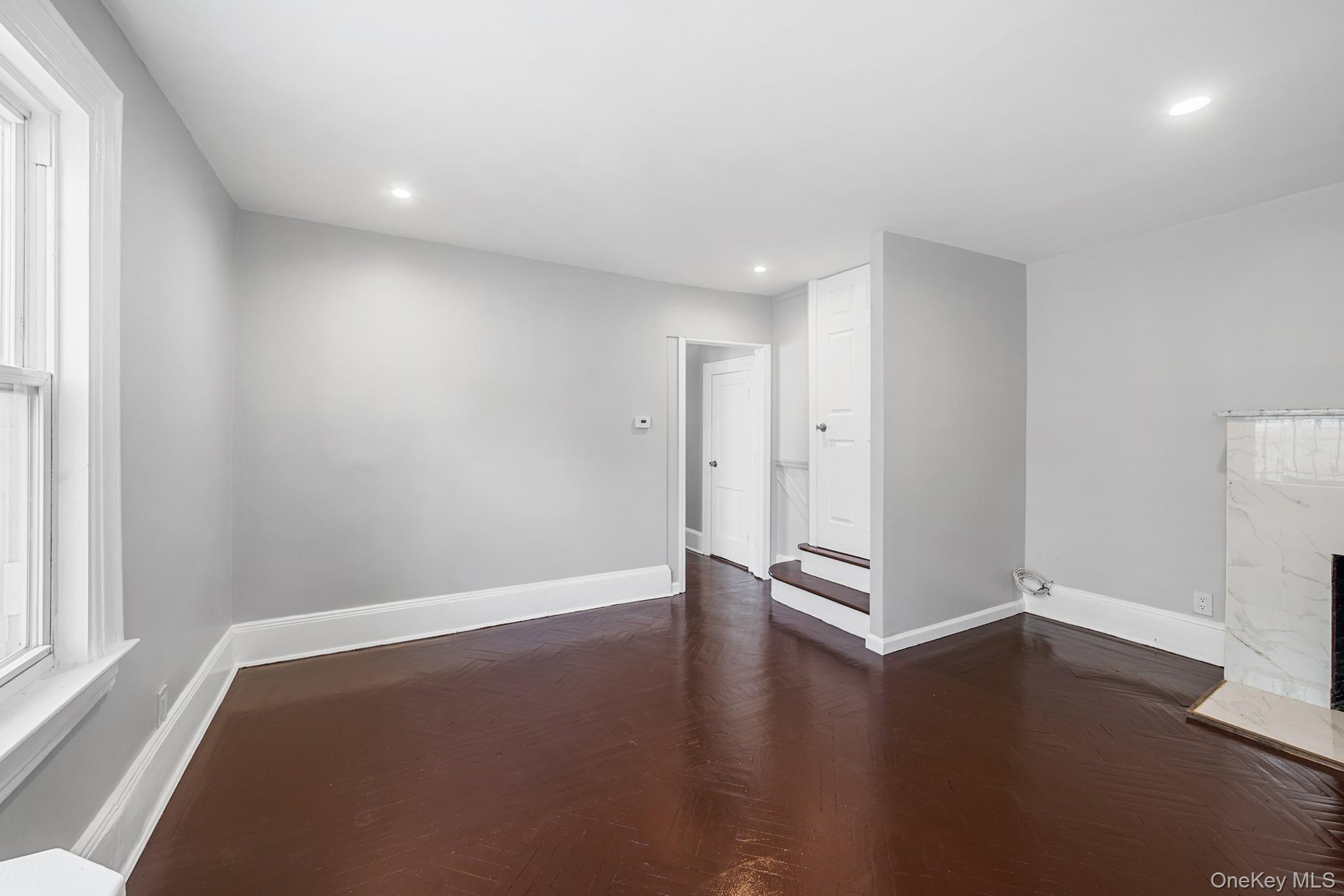150-44 87th Road Queens, NY 11432 - Photo 6 of 35 an empty room with wooden floor and windows