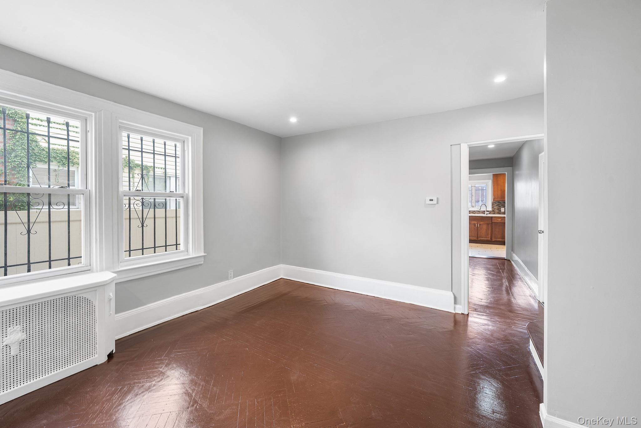 150-44 87th Road Queens, NY 11432 - Photo 10 of 35 an empty room with wooden floor and windows