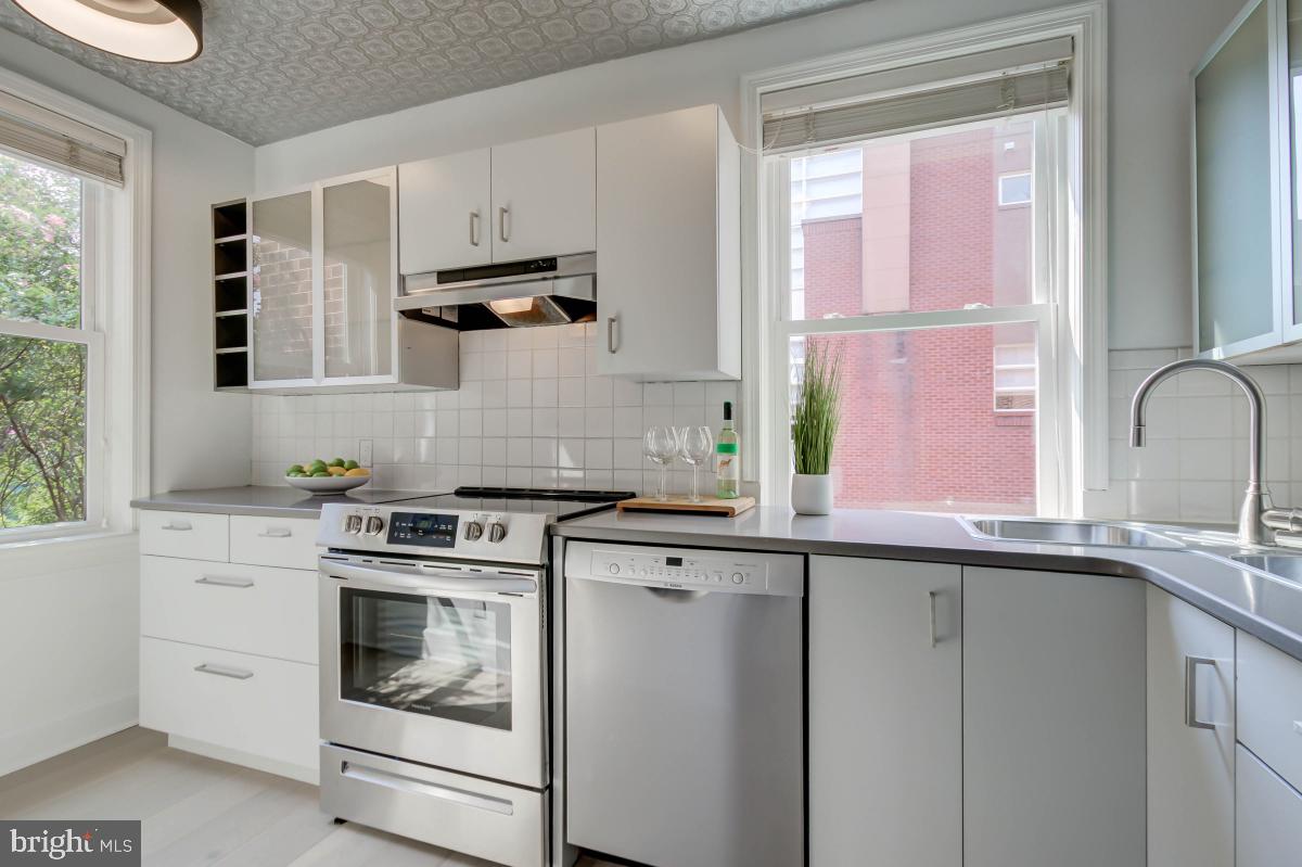 1201 O Street Northwest, Unit 2A Washington, DC 20005 - Photo 17 of 31 a kitchen with stainless steel appliances white cabinets and a stove top oven