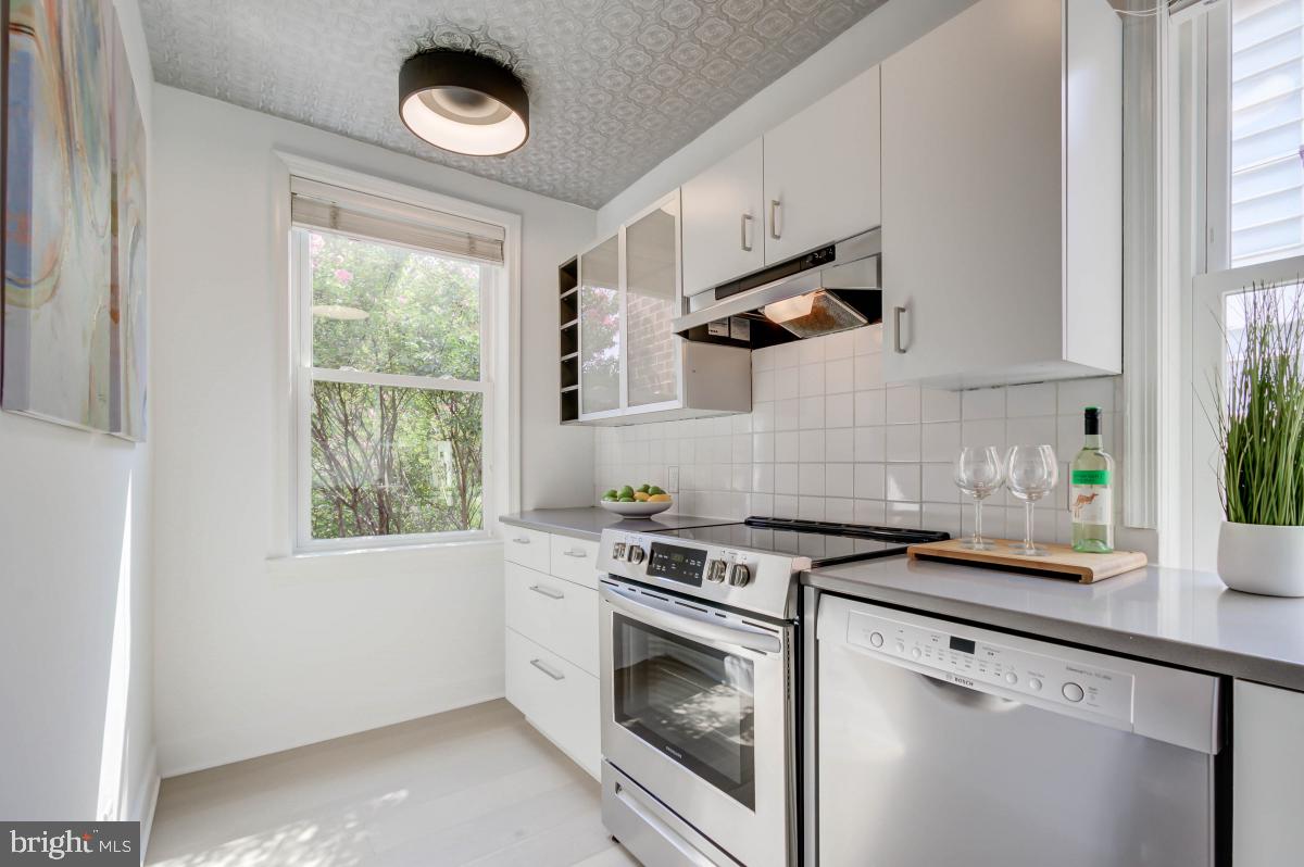 1201 O Street Northwest, Unit 2A Washington, DC 20005 - Photo 18 of 31 a kitchen with granite countertop a stove a sink and a window