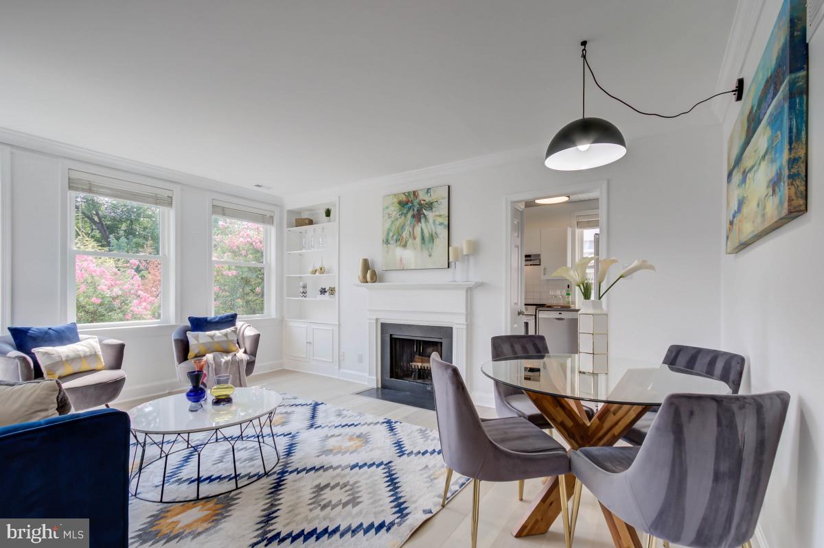 1201 O Street Northwest, Unit 2A Washington, DC 20005 - Photo 6 of 31 a living room with furniture a fireplace and a large window
