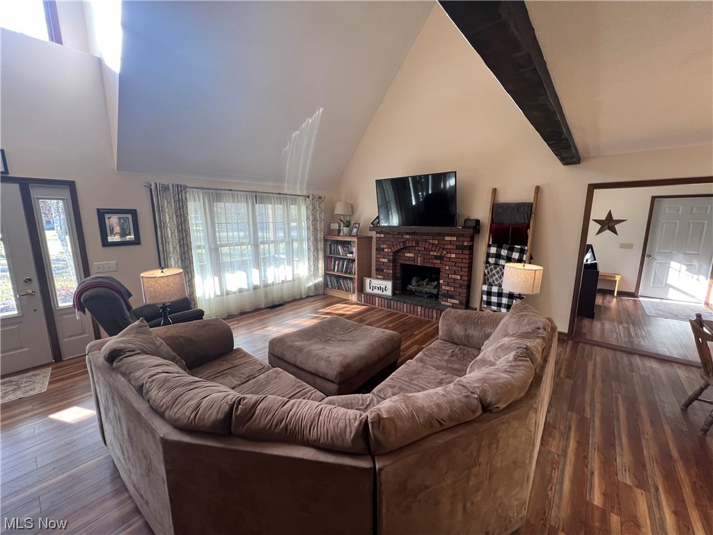 4512 Tabor Ridge Road Northeast Mineral City, OH 44656 - Photo 3 of 44 Living room with beamed ceiling, dark hardwood / wood-style flooring, a fireplace, and high vaulted ceiling