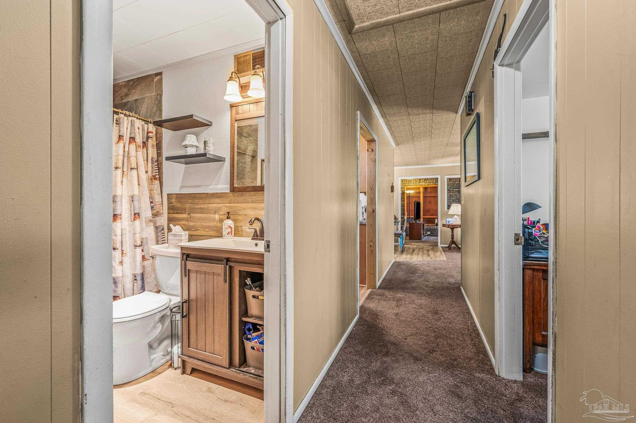 3015 Molino Road Molino, FL 32577 - Photo 18 of 35 a view of a hallway with wooden floor and a bathroom