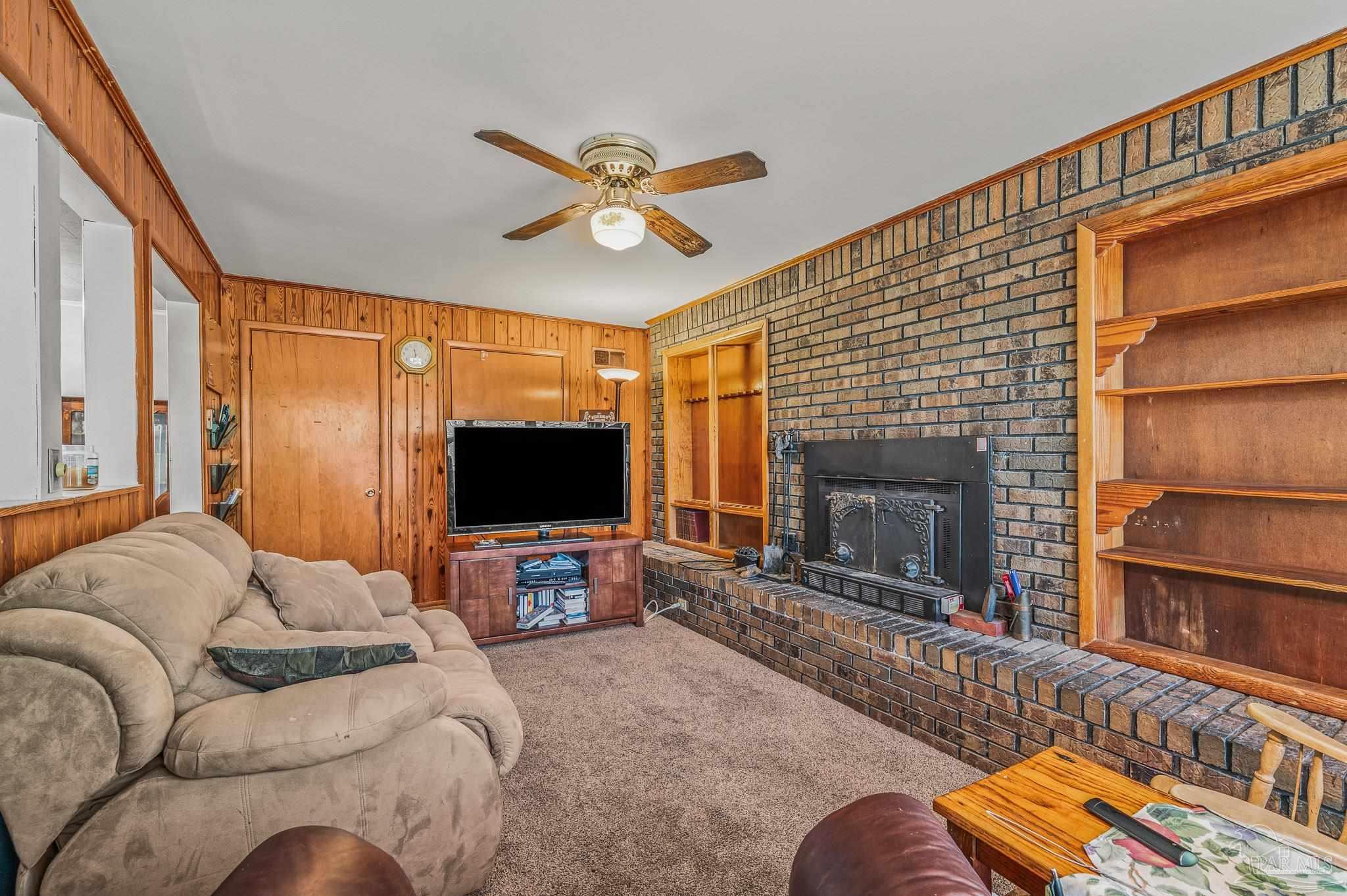 3015 Molino Road Molino, FL 32577 - Photo 25 of 35 a living room with furniture a fireplace and a flat screen tv