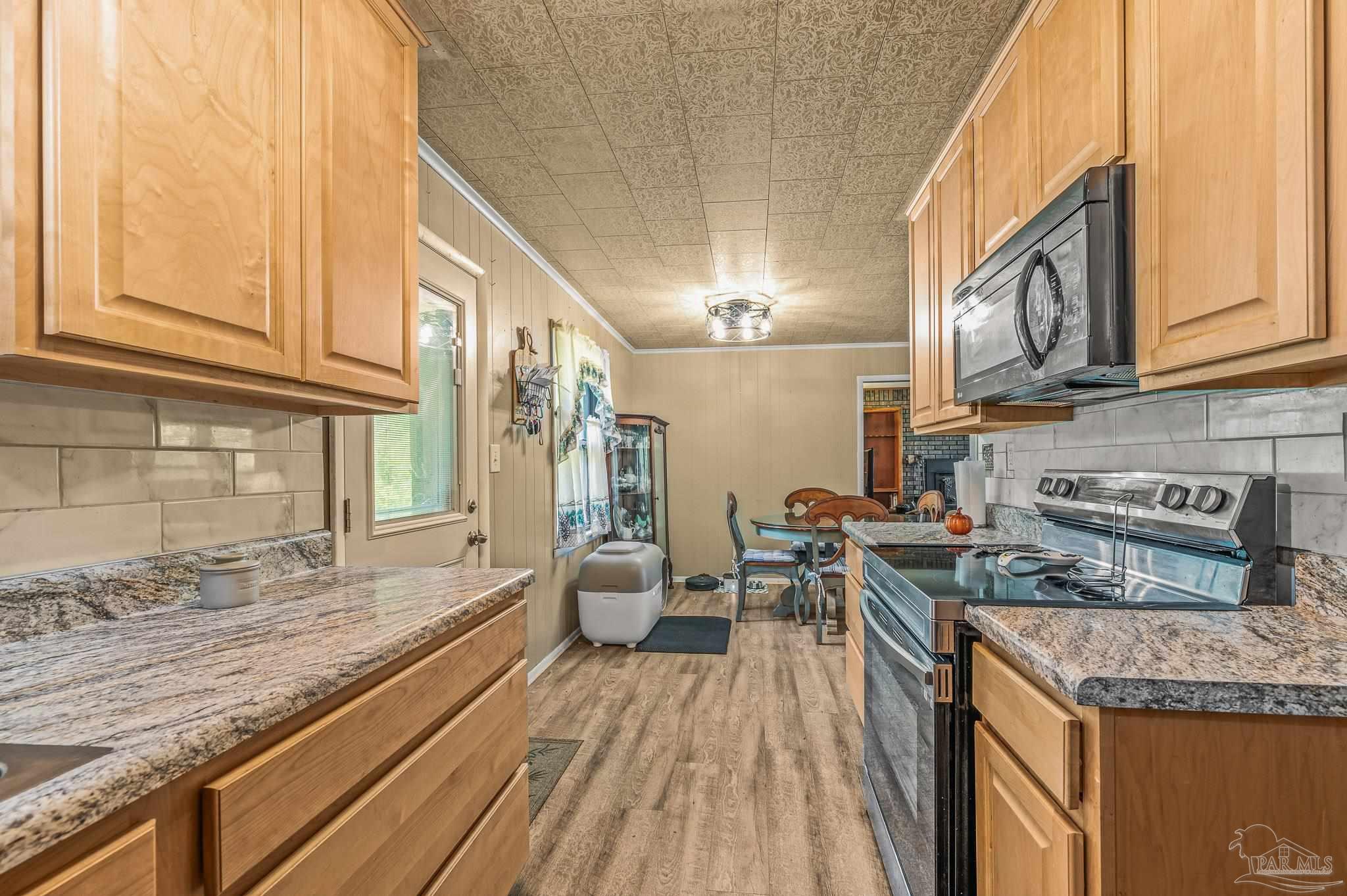 3015 Molino Road Molino, FL 32577 - Photo 34 of 35 a kitchen with stainless steel appliances granite countertop a stove and a wooden cabinets