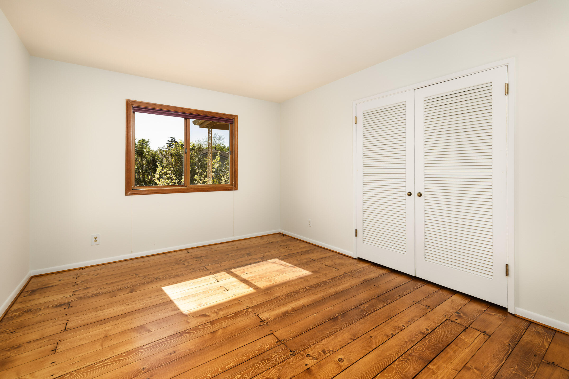 1005 Winther Way Santa Barbara, CA 93110 - Photo 18 of 33 an empty room with wooden floor and windows