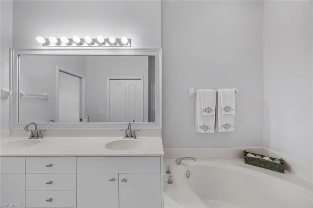 a bathroom with a bathtub a sink and mirror