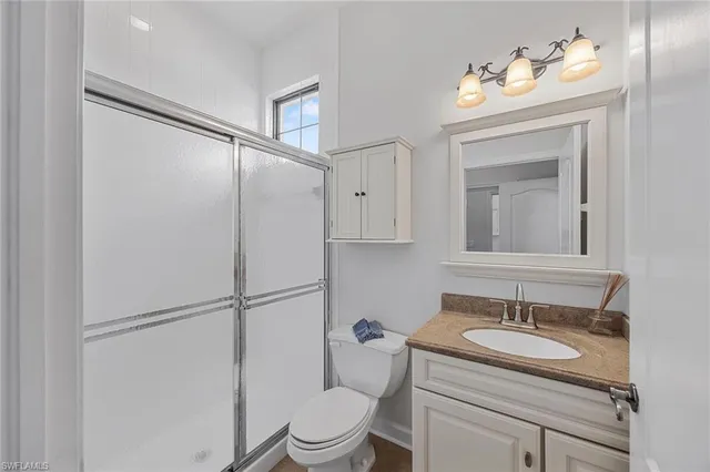 a bathroom with a granite countertop sink mirror vanity and toilet