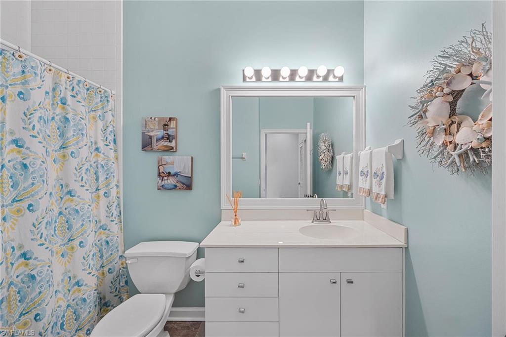 2432 Ravenna Boulevard, Unit 201 Naples, FL 34109 - Photo 26 of 49 a bathroom with a sink a toilet and a mirror