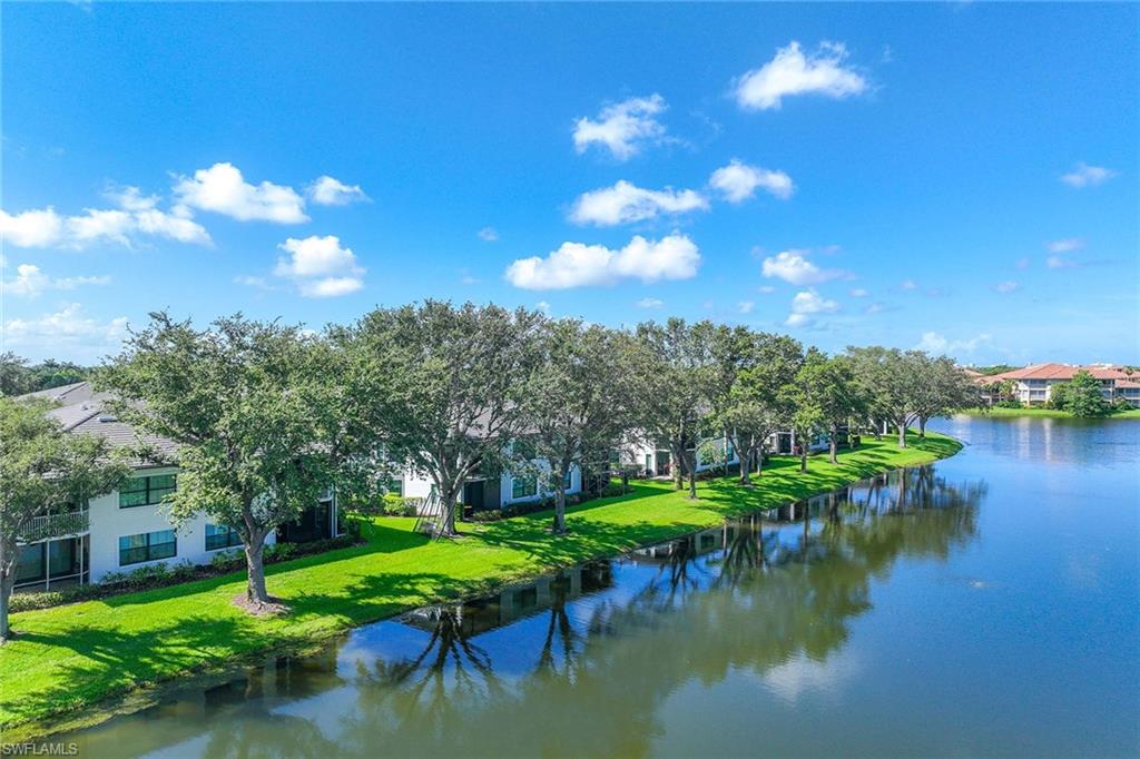 2432 Ravenna Boulevard, Unit 201 Naples, FL 34109 - Photo 35 of 49 a view of a lake with a house in the background