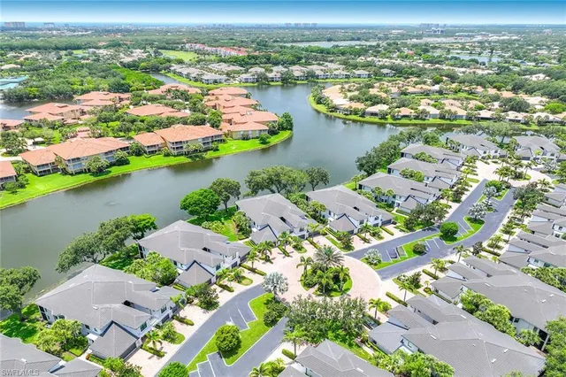 an aerial view of ocean and residential houses with outdoor space