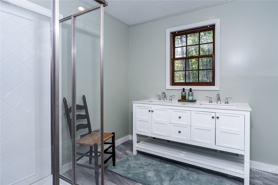 217 Holiday Hills Drive Boone, NC 28607 - Photo 23 of 26 a bathroom with a double vanity sink a mirror and a bathtub