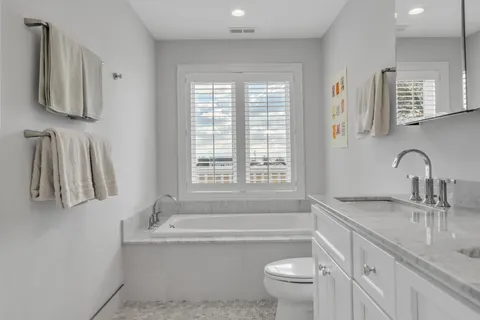 a bathroom with a granite countertop sink a mirror and a shower