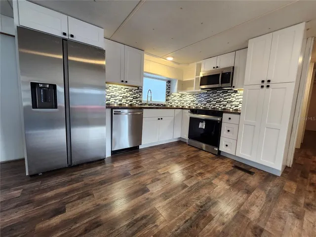 a kitchen with stainless steel appliances granite countertop a refrigerator and a sink