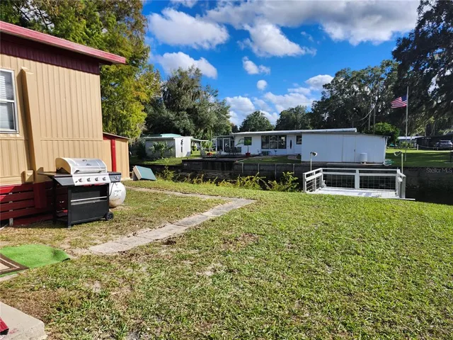 a backyard of a house with table and chairs