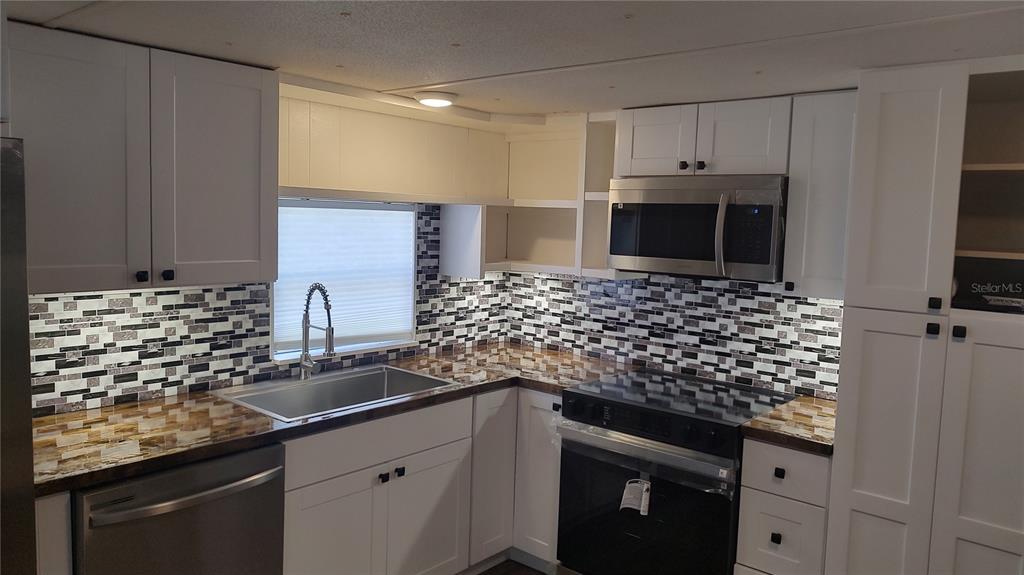 10129 East Bass Circle Inverness, FL 34450 - Photo 34 of 34 a kitchen with granite countertop a sink and cabinets