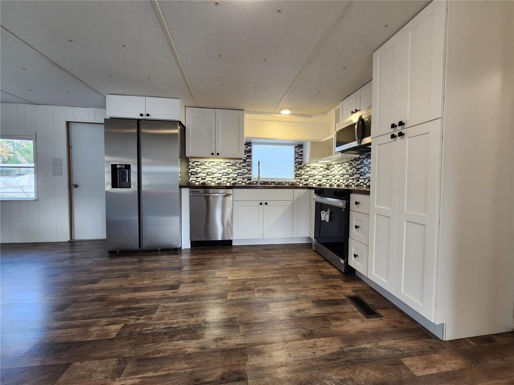 10129 East Bass Circle Inverness, FL 34450 - Photo 5 of 34 a kitchen with stainless steel appliances a refrigerator and a stove