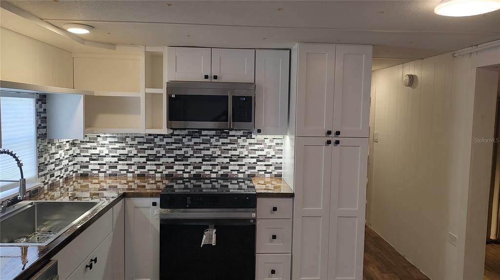 10129 East Bass Circle Inverness, FL 34450 - Photo 6 of 34 a bathroom with a granite countertop sink and washing machine