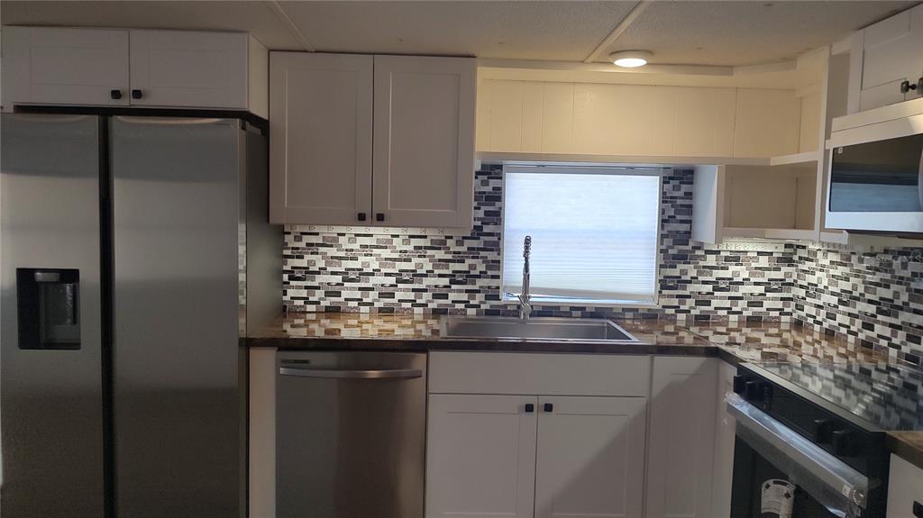 10129 East Bass Circle Inverness, FL 34450 - Photo 8 of 34 a kitchen with kitchen island a counter top space cabinets and stainless steel appliances