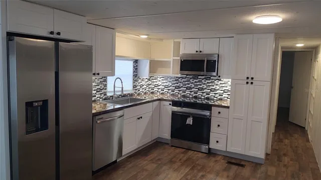 a kitchen with stainless steel appliances granite countertop a refrigerator and a sink