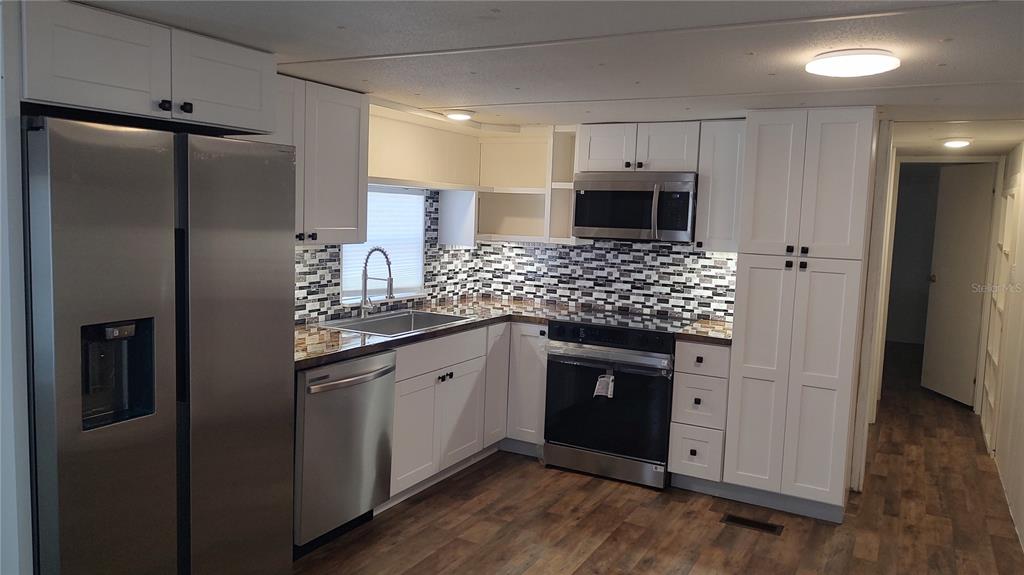 10129 East Bass Circle Inverness, FL 34450 - Photo 9 of 34 a kitchen with stainless steel appliances granite countertop a refrigerator and a sink