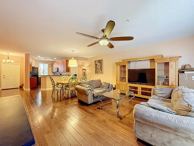 a view of a livingroom with wooden floor and furniture