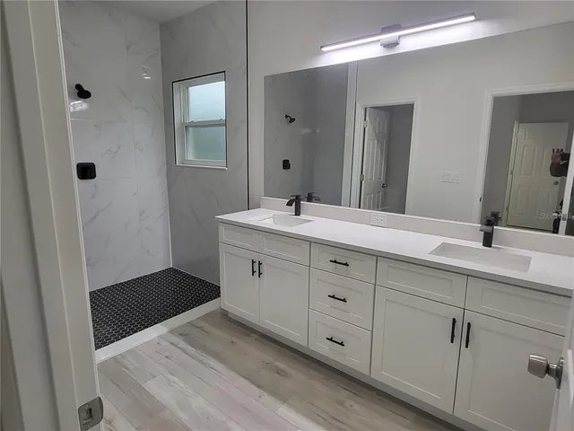 a bathroom with a sink a mirror and a shower
