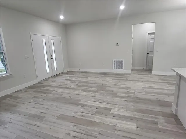 a view of an empty room with wooden floor