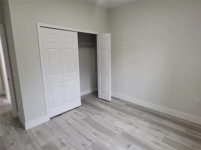 an empty room with wooden floor and closet