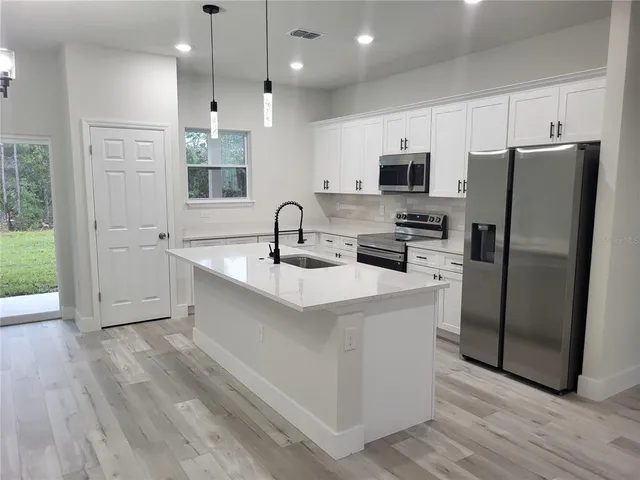 a kitchen with stainless steel appliances a refrigerator sink and microwave